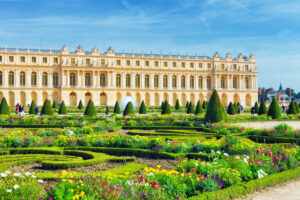 The majestic entrance of the Royal residence at Versailles, featuring intricate details and expansive gardens.