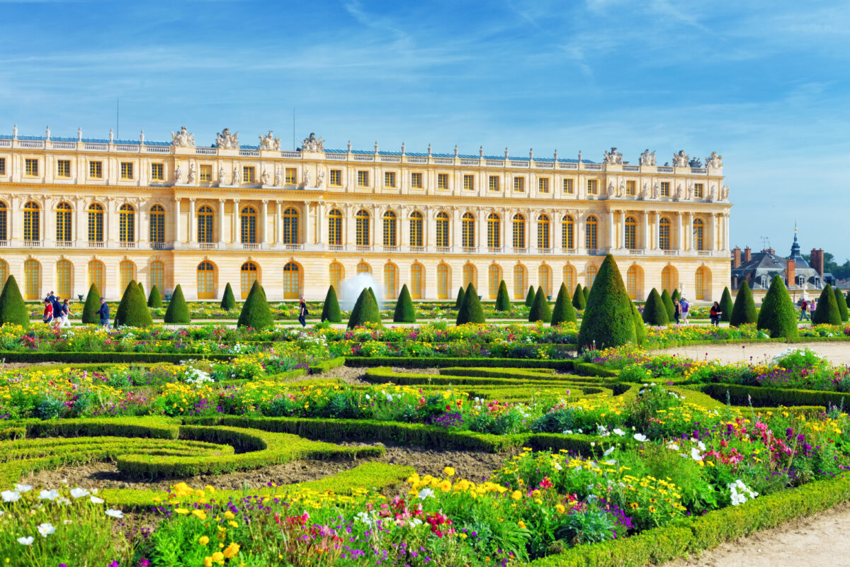 The majestic entrance of the Royal residence at Versailles, featuring intricate details and expansive gardens.