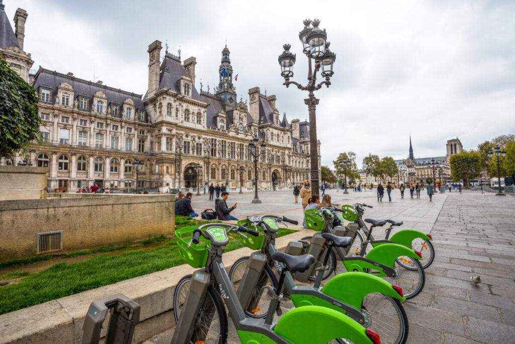 The Hotel de Ville, Paris City Hall, with rental bikes in front, showcasing the building's grandeur and administrative function.