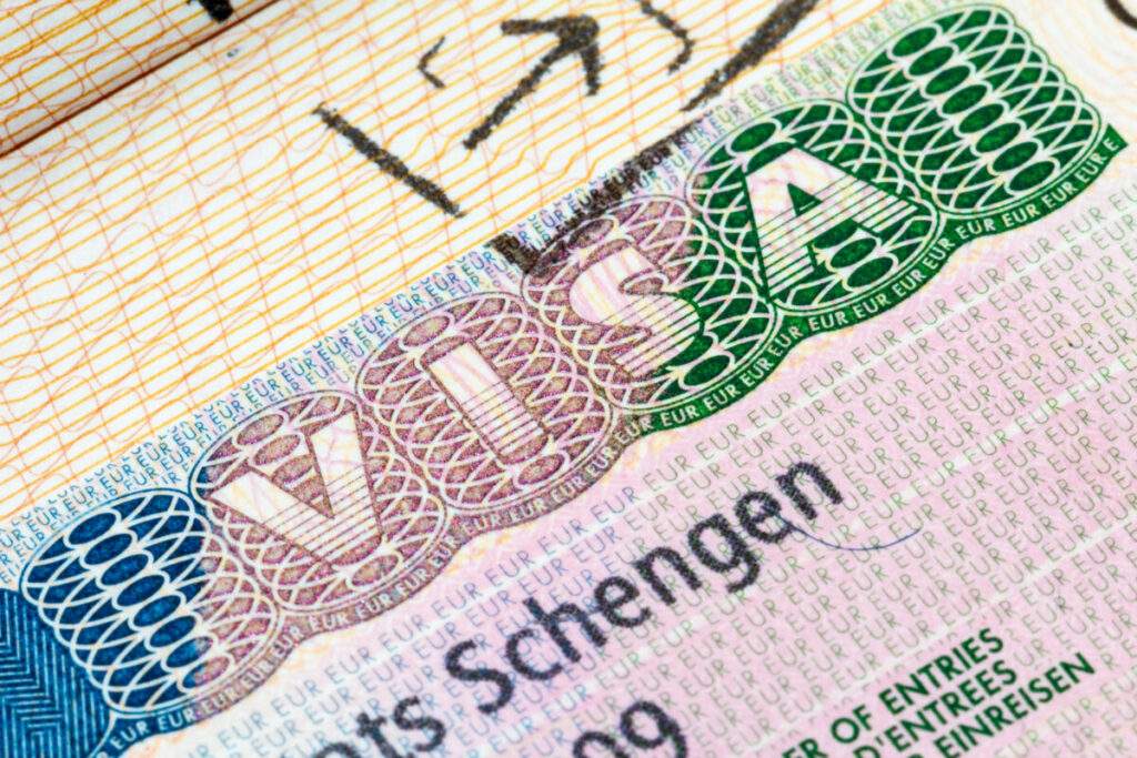 Close-up of a Schengen visa stamped in a passport, showing detailed information and official markings.
