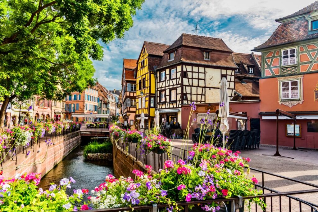Scenic view of a river lined with colorful buildings in Colmar, Alsace, showcasing the charm of the old houses.
