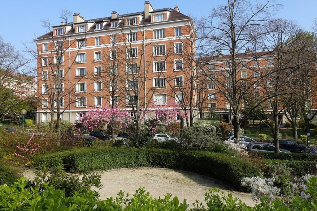 Spacious building featuring many windows, situated within the Coulée Verte René-Dumont Nature area.S