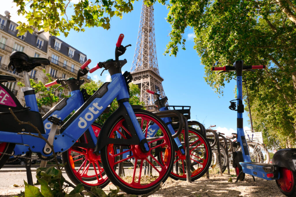 Self-service electric bikes from Dott brand lined up for rental in the Eiffel Tower district, promoting eco-friendly transport.
