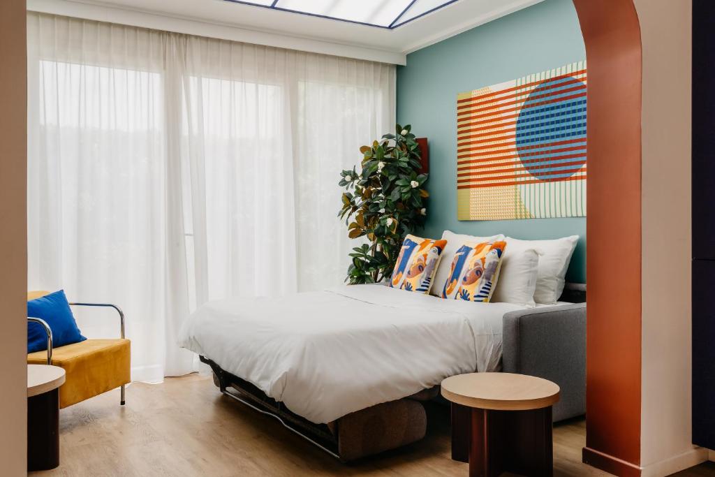 Bed and room interior in Edgar Suites Auteuil – Le Marois