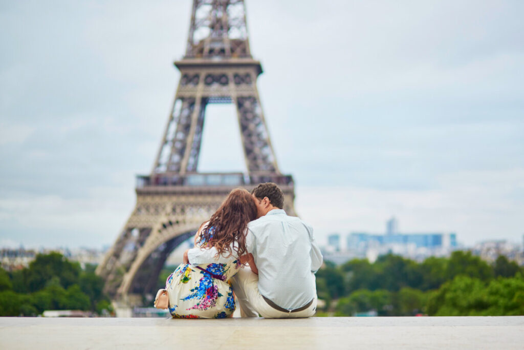 Couple shares a romantic moment near the Eiffel Tower in Paris, capturing the essence of love and togetherness.