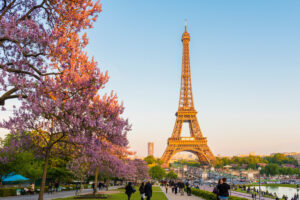 Eiffel Tower in Paris during spring at sunset, showcasing a vibrant sky and the iconic structure silhouetted against it.