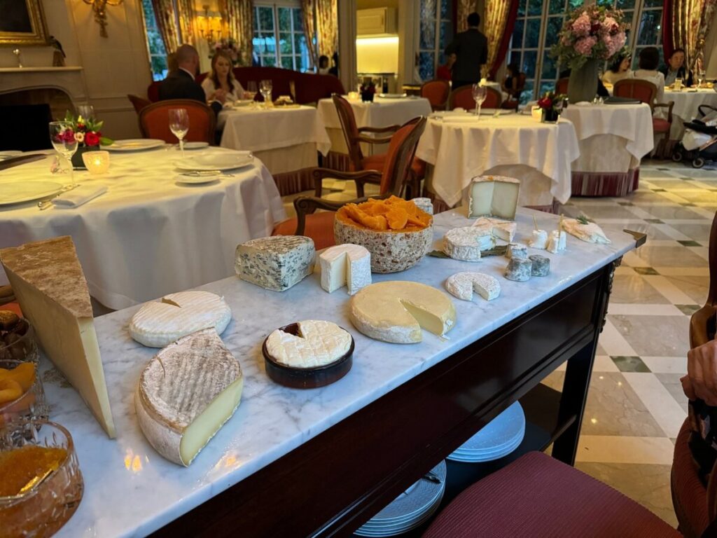 Various cheeses displayed on a platter in the elegant setting of the Epicure Paris restaurant