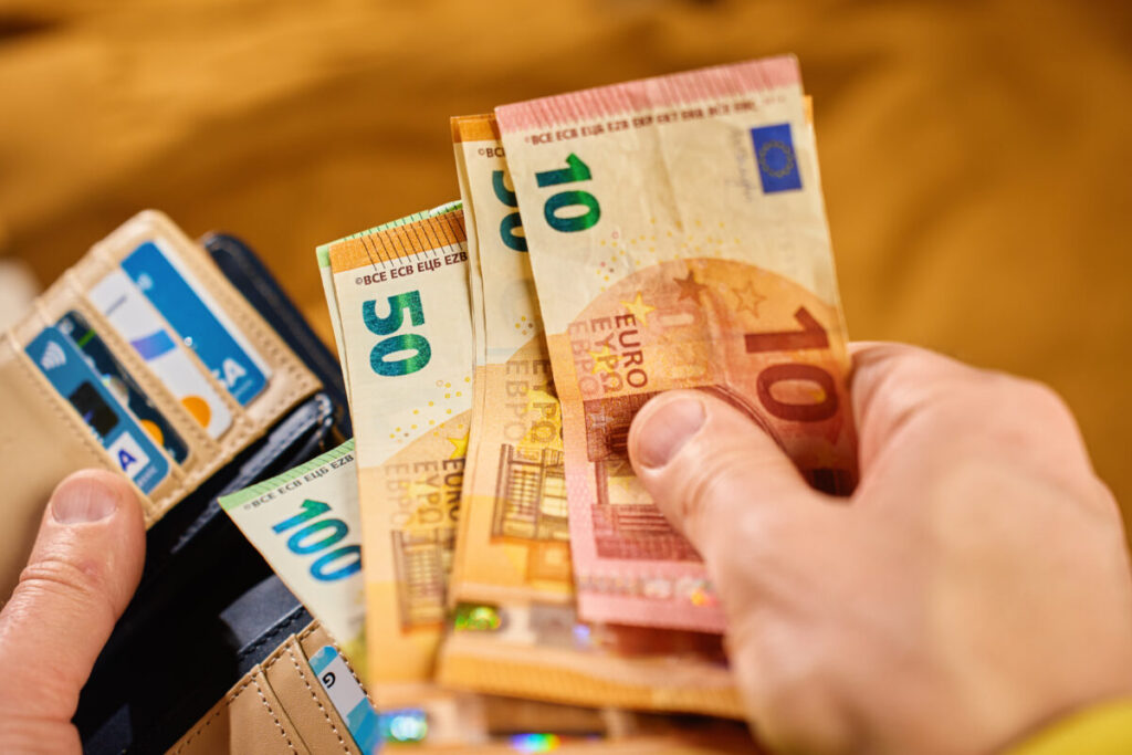 Close-up of a wallet filled with euro banknotes and credit cards, representing personal finance and cash management.