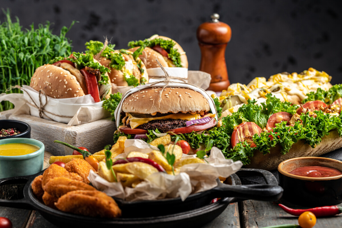 Set of Homemade burgers with grilled meat, vegetables, sauce French fries on rustic wooden background. 