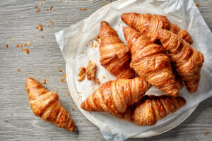 Close-up of freshly baked croissants, showcasing their golden-brown, flaky layers and inviting texture.