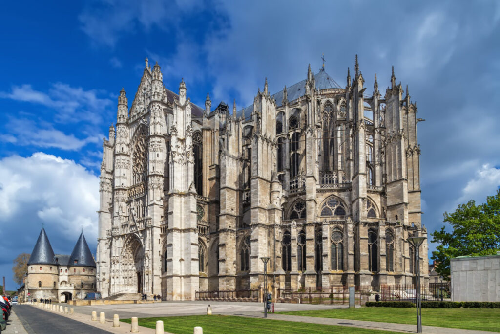 Stunning Gothic architecture of Beauvais Cathedral in France, showcasing intricate details and soaring spires against a blue sky.