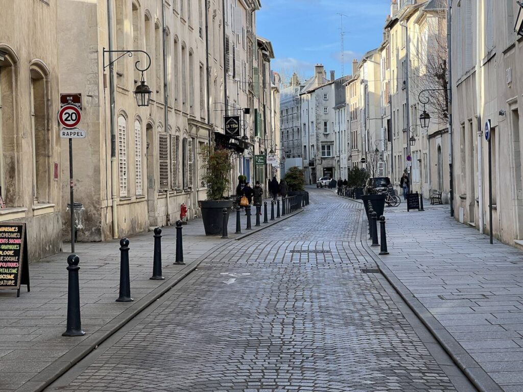 Street scene on Grande Rue, France, featuring a person walking among a few buildings.