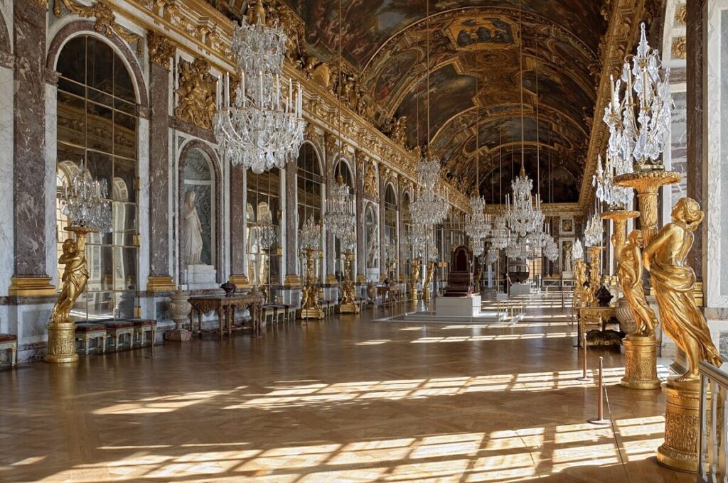 The stunning Château de Fontainebleau, France, with a large building and a peaceful pond situated in front of it.