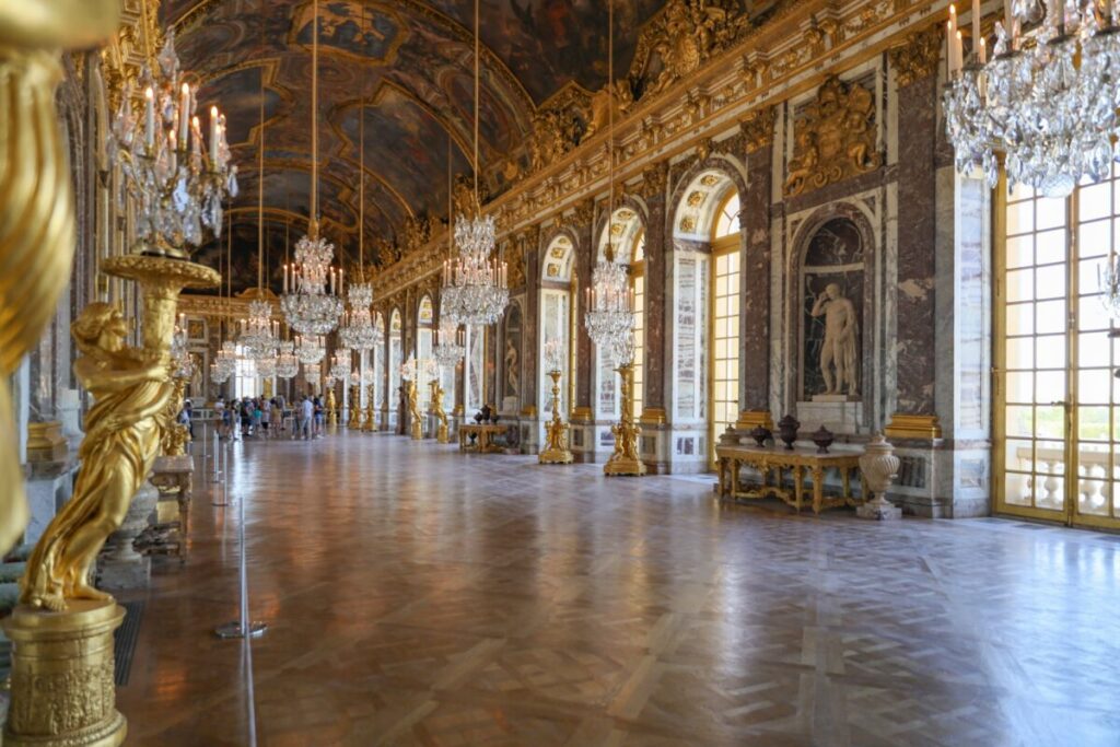 Tourists and interior of Hall of Mirrors in Versailles, France