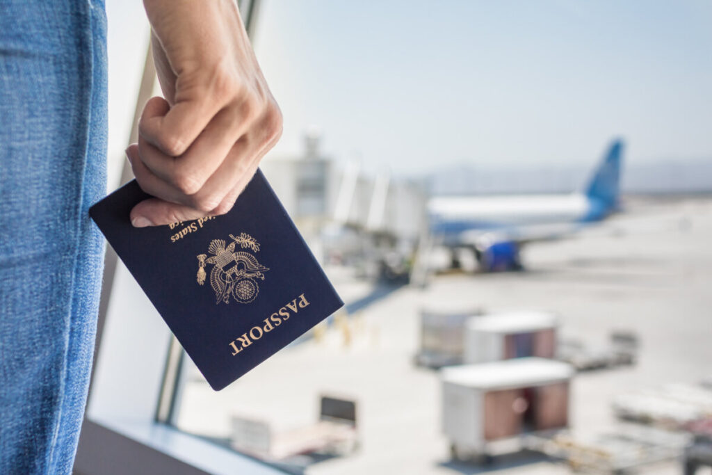 Close-up of a hand gripping a USA passport in an airport setting