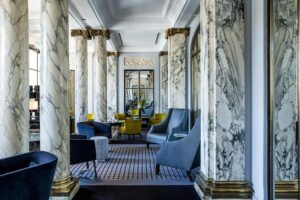 The featured image showcases the grand facade of Hôtel Brighton - Esprit de France, adorned with ornate architectural details and tall windows overlooking the iconic Jardin des Tuileries.