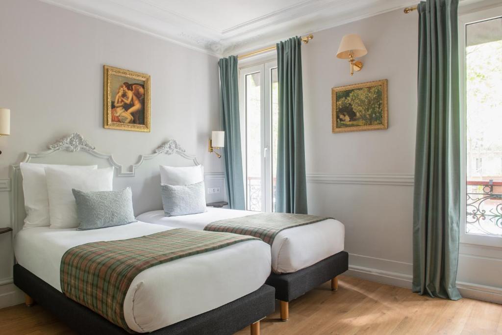 Interior of Hôtel De La Porte Dorée, showcasing a room with two beds and a window, designed for comfort and relaxation.