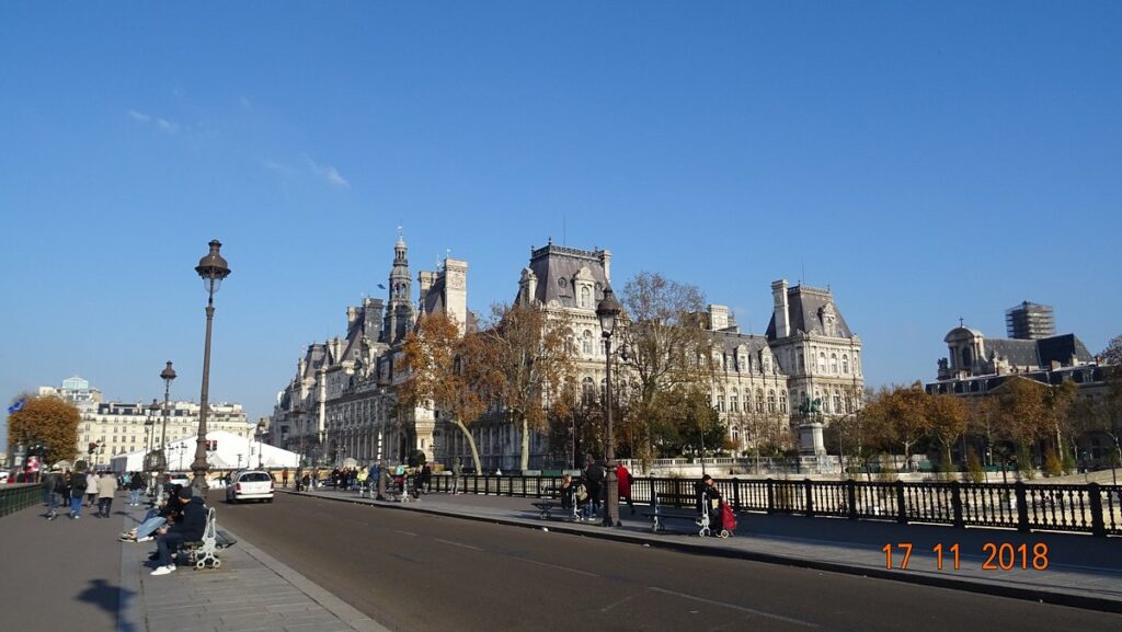 Tourists exploring attractions near the statue of Étienne Marcel, including historical buildings and local cafes in the bustling area.