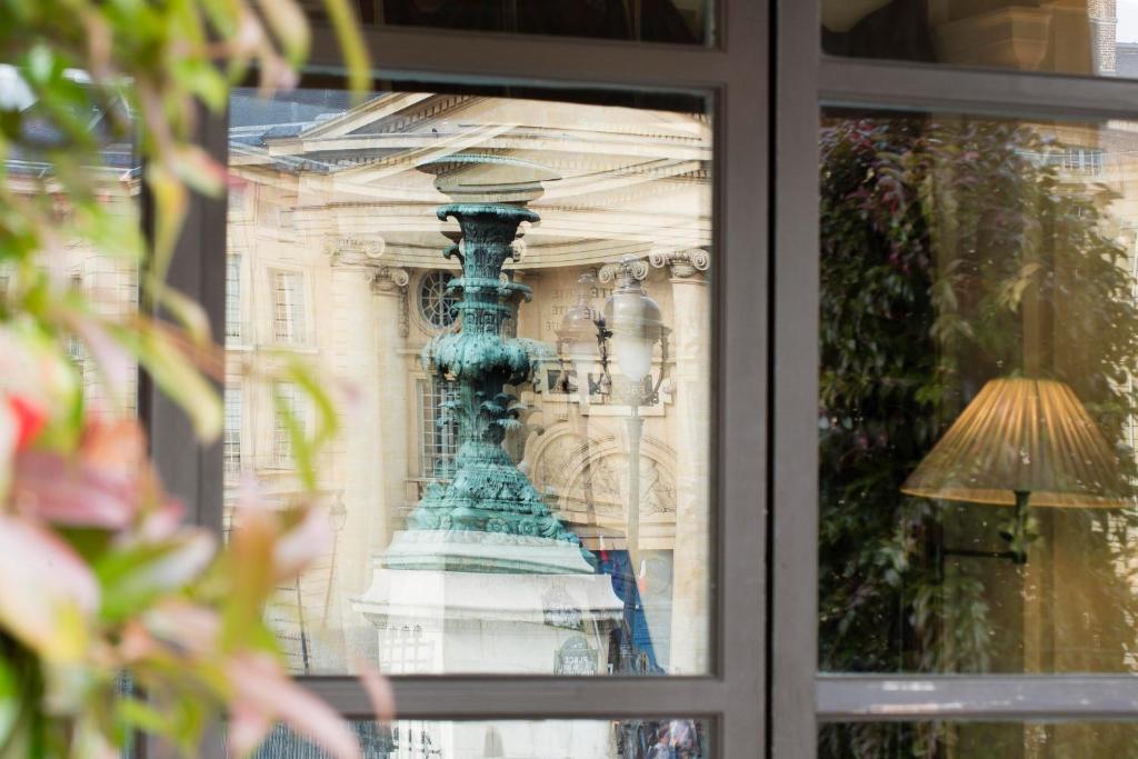 The Hôtel des Grands Hommes' foyer, with its elaborate furnishings and cozy atmosphere, combines modern comforts with ancient grandeur to create a captivating scene.