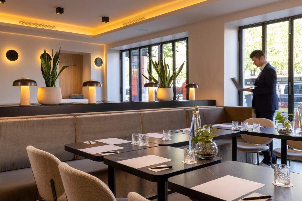 The chic dining area at Hôtel Esté Paris, adorned with modern decor and softly lit ambiance, offering a sophisticated setting for gourmet dining.