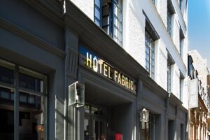 Exterior view of Hôtel Fabric with its historic facade adorned with ornate details and tall windows.