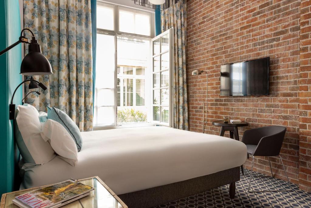 Luxurious hotel room at Hôtel Fabric with modern furnishings, cozy bedding, and elegant decor.