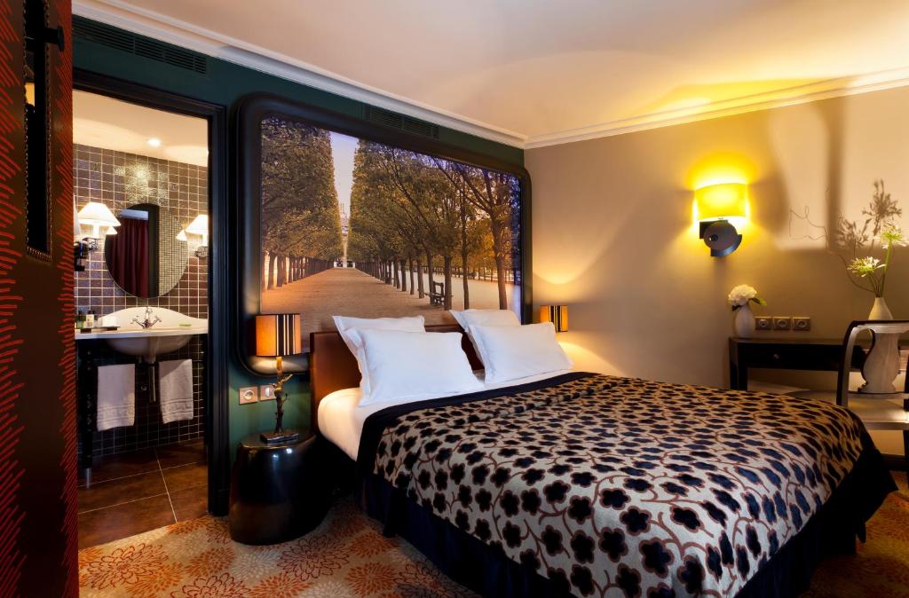 Hotel Fontaines du Luxembourg room featuring two beds and a decorative painting on the wall.