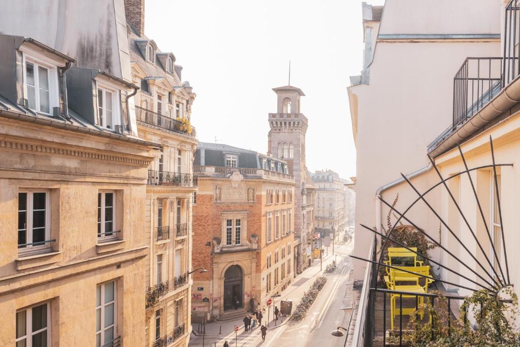 Hotel Le Petit Paris exterior, showcasing a charming facade with ornate details and flower-adorned balconies.