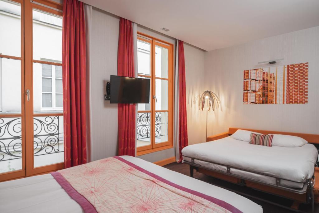 A cozy and intimate hotel room at Hotel Le Petit Paris, featuring stylish decor, a comfortable bed with crisp linens, and soft lighting.