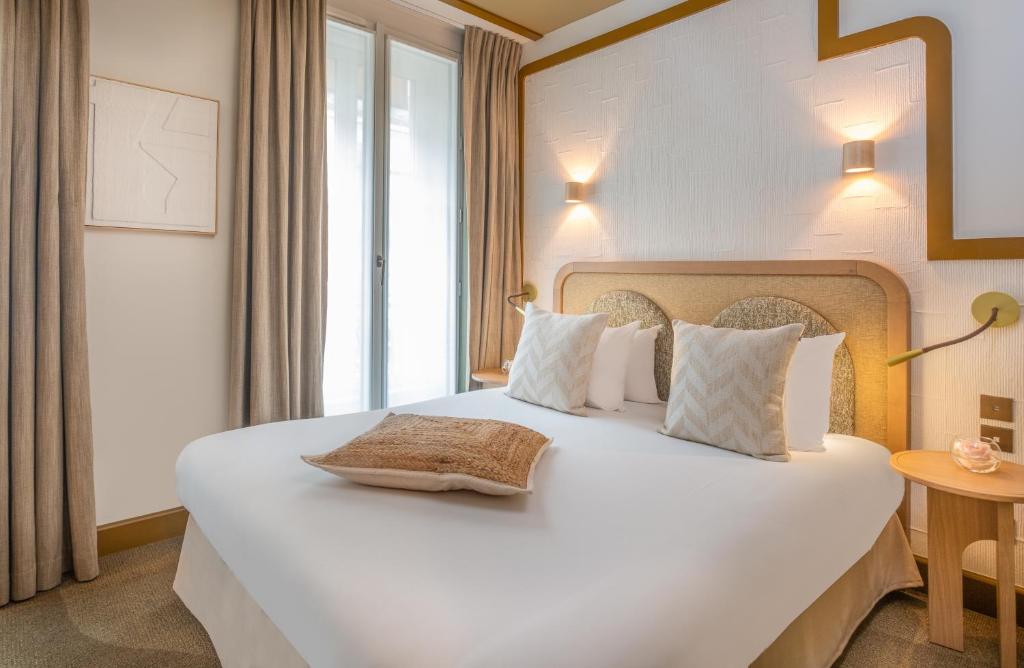 Interior of a Hôtel Mona Lisa room showcasing a bed, a chair, and a lamp, designed for comfort and relaxation.