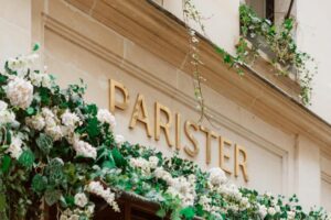 The elegant facade of Hotel Parister & Spa, featuring modern architectural design with clean lines, floor-to-ceiling windows, and greenery adorning the exterior.