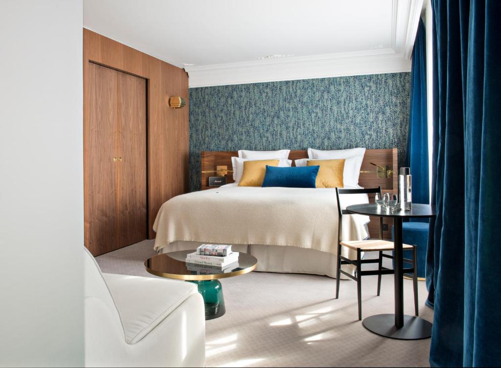 A luxurious hotel room at Hotel Parister & Spa, featuring contemporary furnishings, a plush bed with premium linens, and large windows offering views of the cityscape.