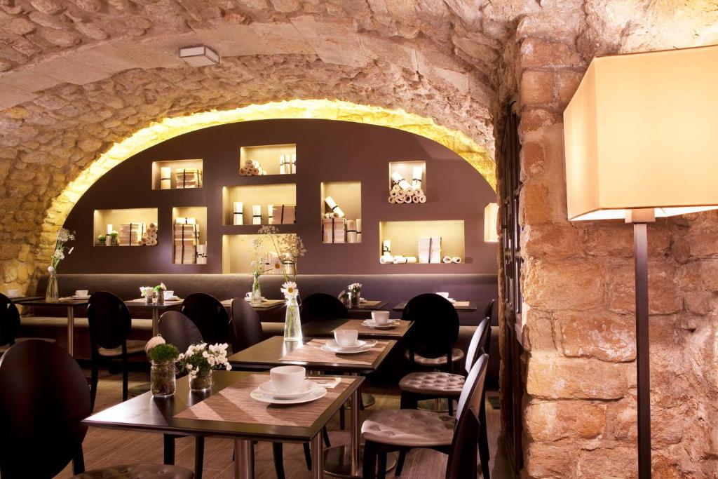 The intimate dining area at Hotel Verneuil Saint Germain, featuring chic decor, soft lighting, and tables set with fine tableware.