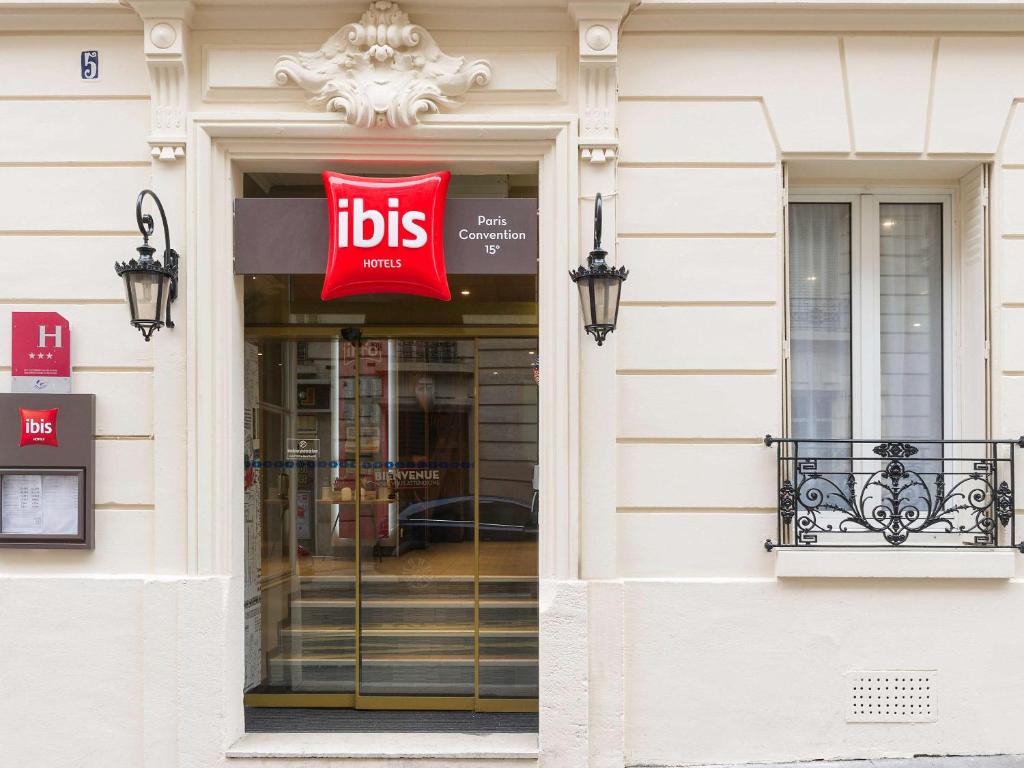 Exterior view of Ibis Paris Vaugirard Porte de Versailles, showcasing a modern and welcoming facade with vibrant signage.