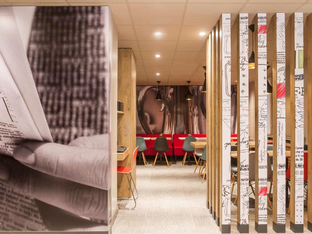 The lobby of Ibis Paris Vaugirard Porte de Versailles presents a sophisticated and inviting ambiance, featuring chic furnishings, subtle lighting, and attentive staff