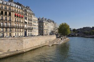 Scenic view of the Île Saint-Louis Riverside featuring a bridge and a building alongside the river.