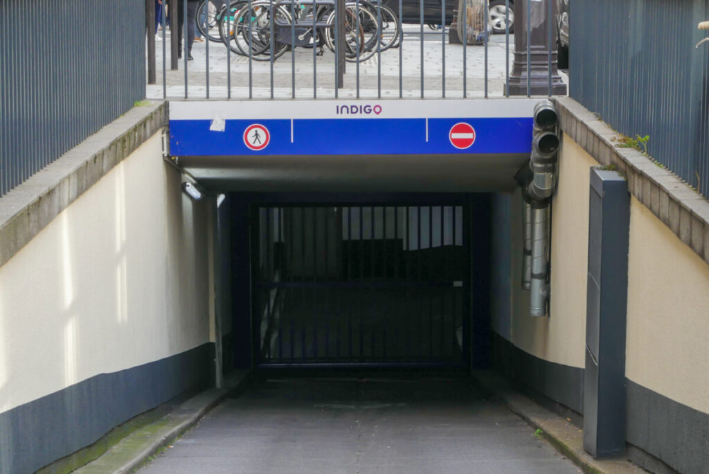 Entrance to an Indigo underground parking garage in Paris, accommodating cars and motorbikes.