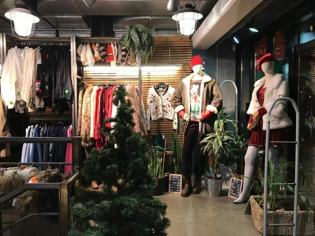 Interior of Kilo Shop Paris Saint-Germain, showcasing a variety of clothes for sale in a vibrant, organized setting.