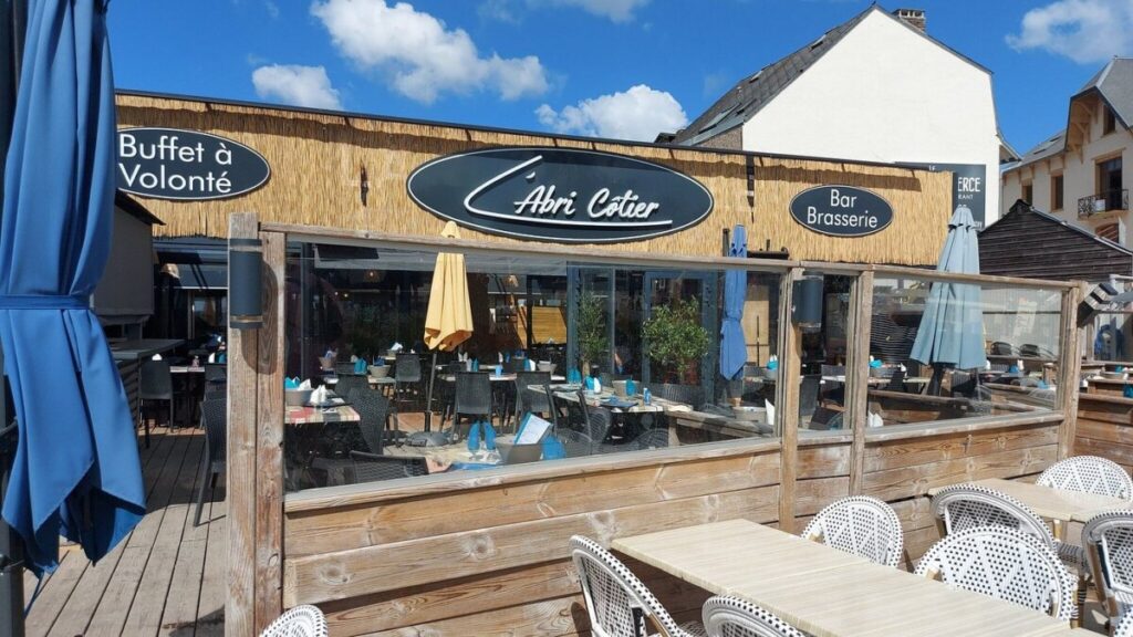 Outdoor patio of L'Abri-Cotier restaurant in Paris, featuring tables and chairs for dining.