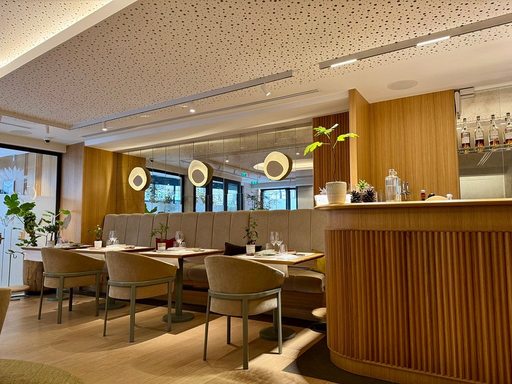 Interior of L’Astrance Paris, highlighting wooden walls and a stylish bar, creating a warm dining environment.