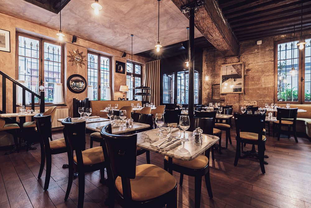 Interior of L'Enoteca Paris featuring neatly arranged tables and chairs in a cozy restaurant setting.