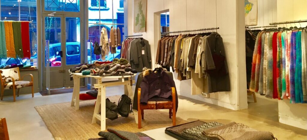 Interior of L’Habilleur Paris, featuring a diverse selection of clothing items displayed on racks and shelves.