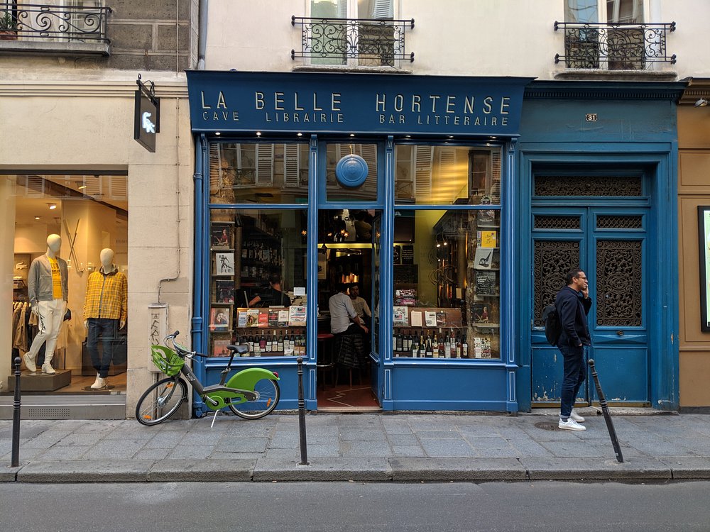 La Belle Hortense, a blue building in Paris, France, featuring a bicycle parked at its entrance.