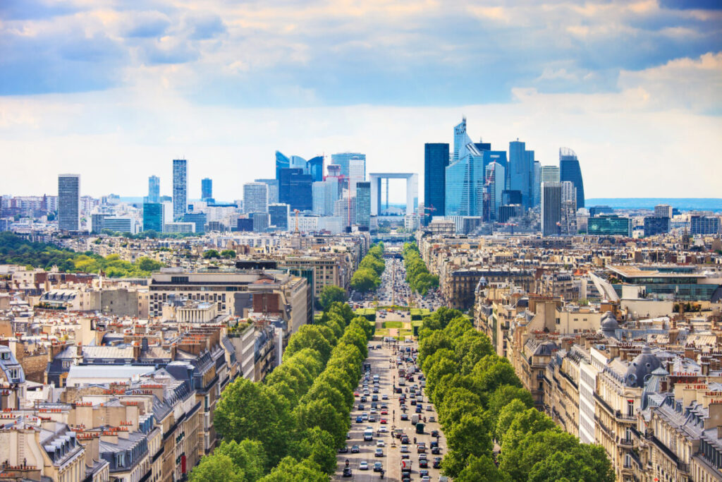 Panoramic view of La Defense, showcasing modern skyscrapers and architecture against a clear blue sky in Paris, France.