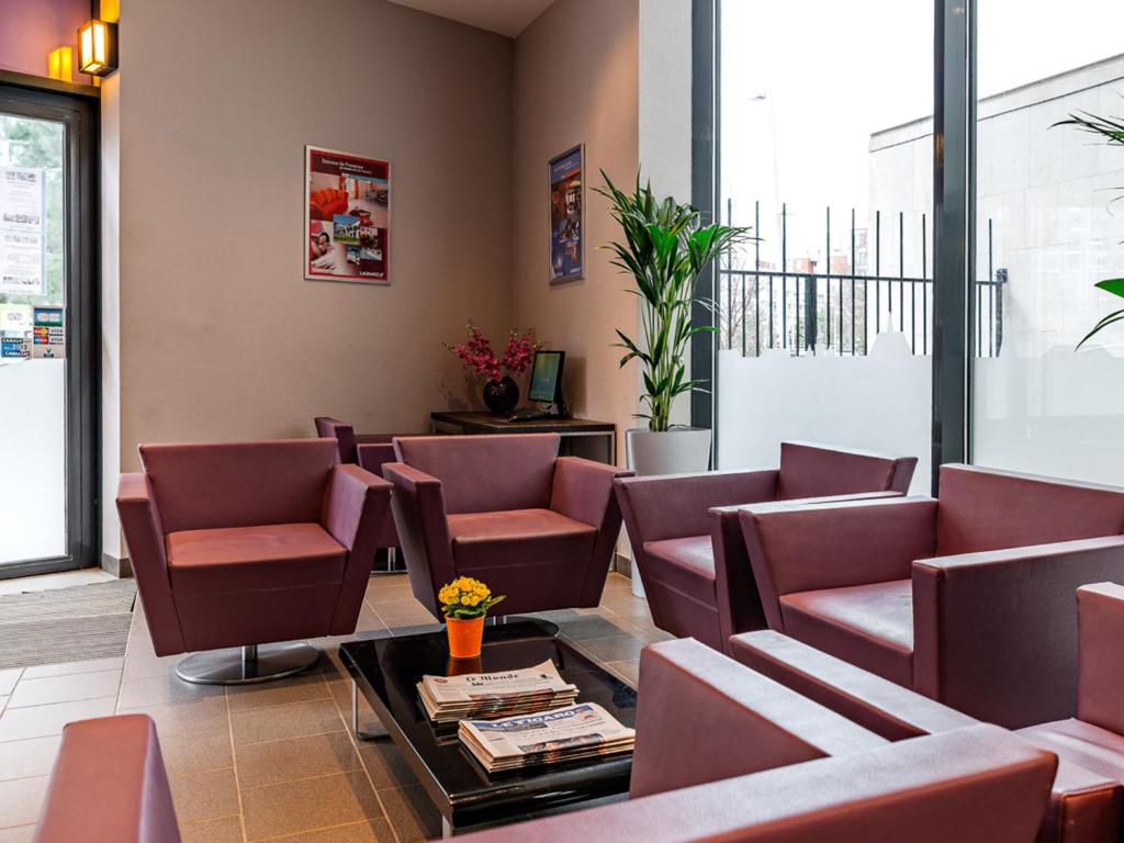 The lobby at Lagrange Apart'Hôtel Paris-Boulogne offers a seamless blend of sophistication and warmth, featuring chic furnishings, ambient lighting, and a tasteful décor