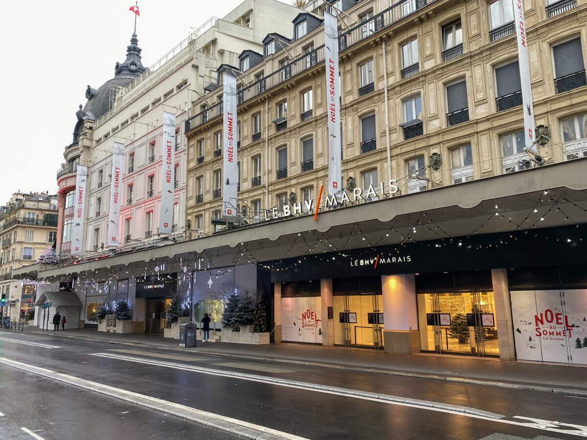 Le Marais shops in Paris, showcasing a large building alongside a car on the street.