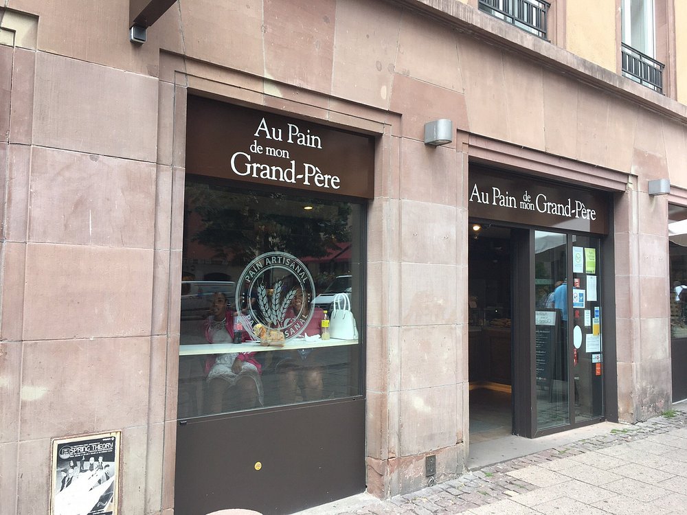 The exterior of Le Pain de Mon Grand-Père in Paris, showcasing a sign that says "Au Pain de Mon Grand-Père."