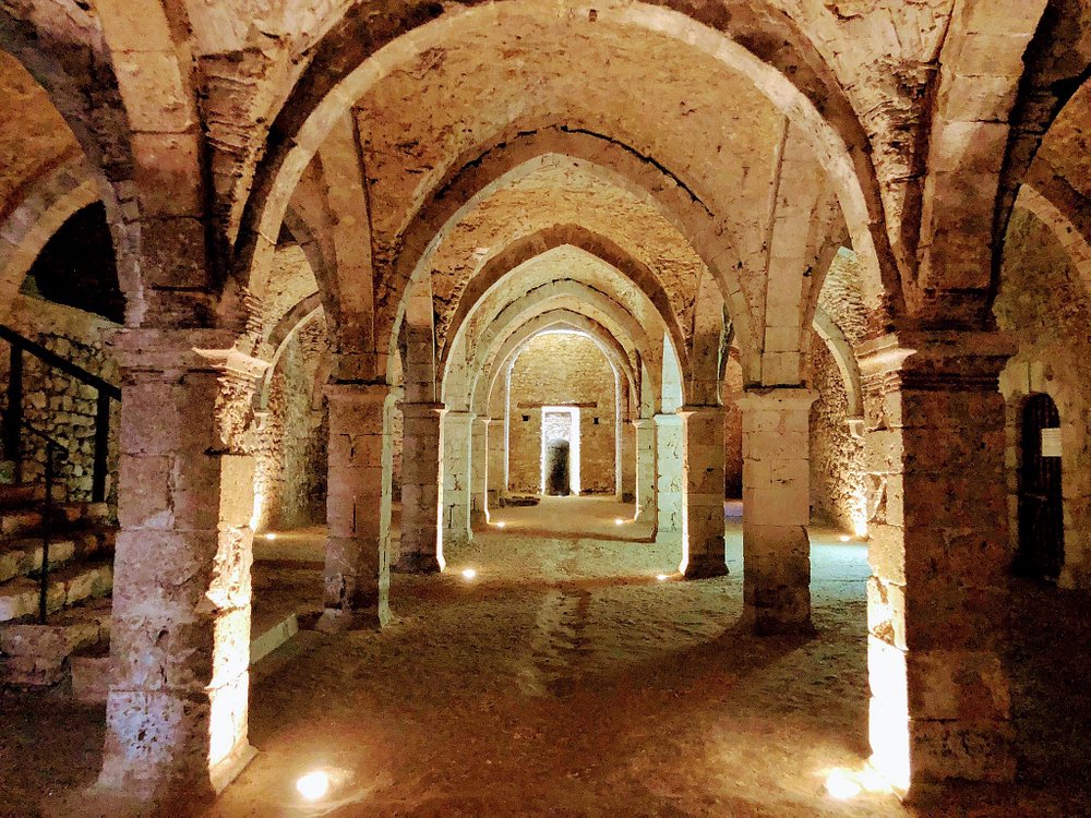 Interior view of Les Souterrains de Provins, showcasing old stone arches and pillars in a historic building.