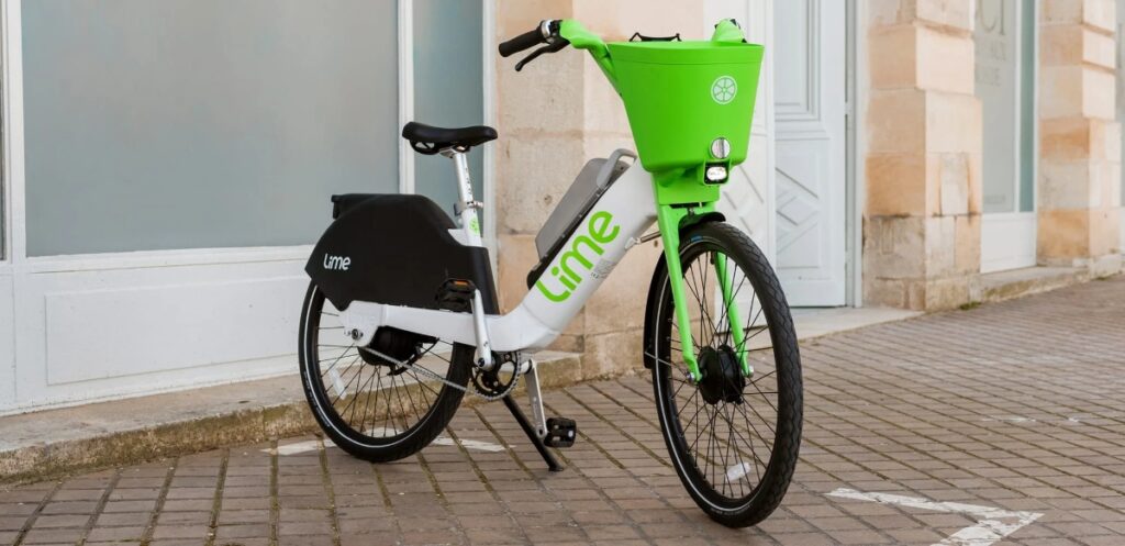 Close-up of a Lime Hero bike, showcasing its vibrant green color and sleek design against a blurred background.