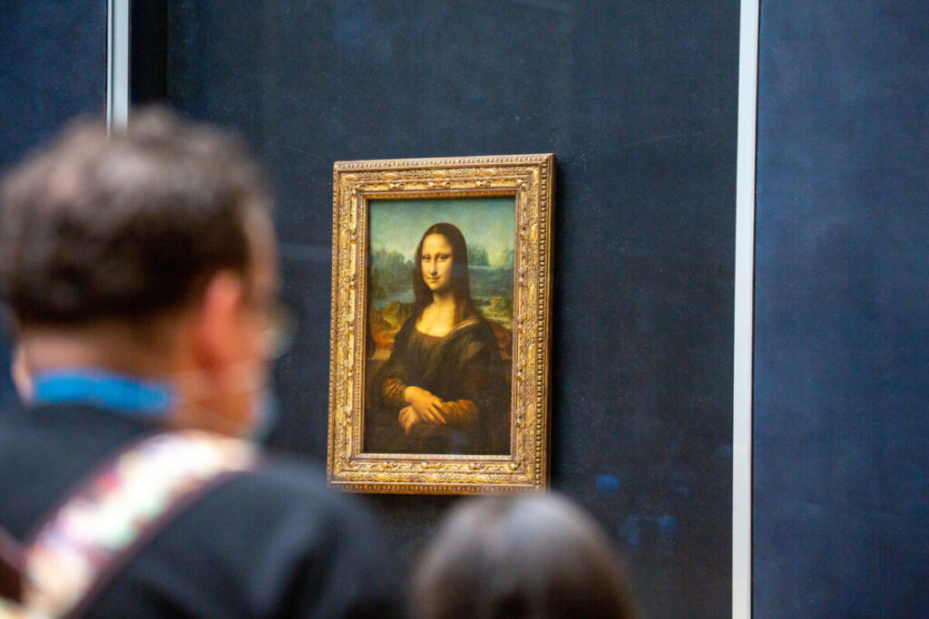 The Mona Lisa, a famous painting by Leonardo da Vinci, displayed in the Louvre Museum, features a woman with a serene expression.